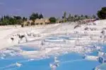 White terraces of Pamukkale Hot Springs in Turkey, reflecting sunlight.