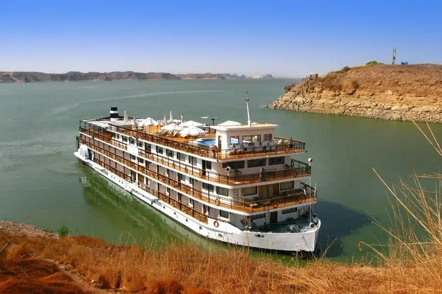 Luxurious Nile cruise ship sailing past ancient Egyptian landmarks.