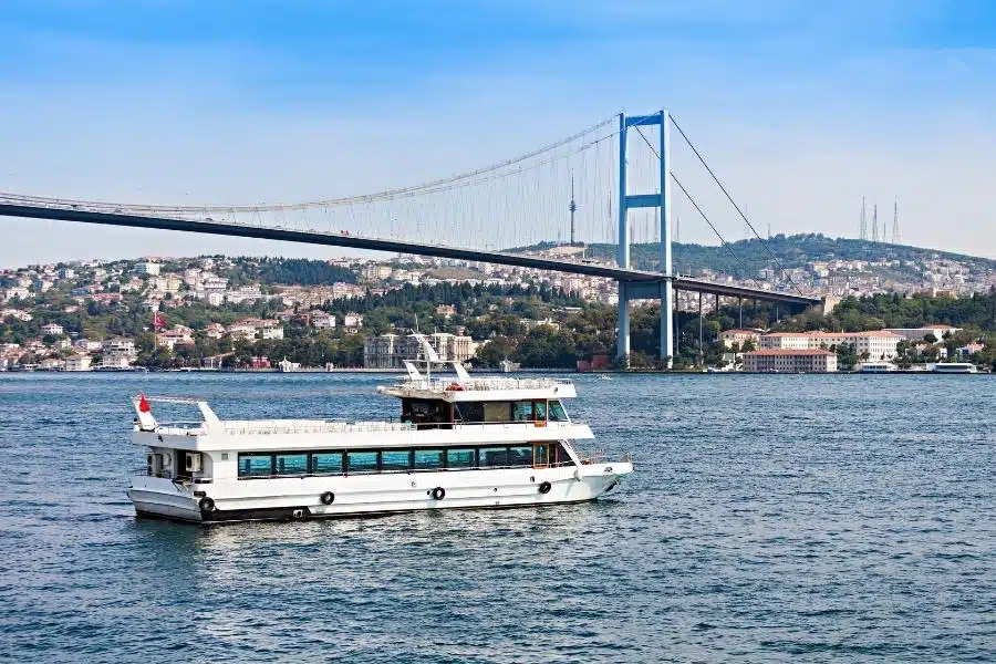 Scenic view of a Bosphorus cruise ship sailing through Istanbul, showcasing historic landmarks and city skyline.