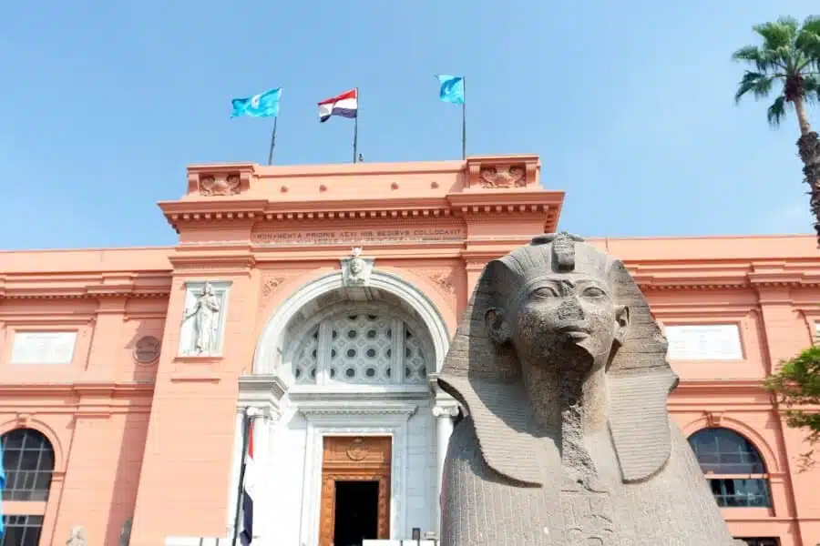 Egyptian Museum in Cairo facade with pinkish walls, grand columns, and historical artifacts on display.